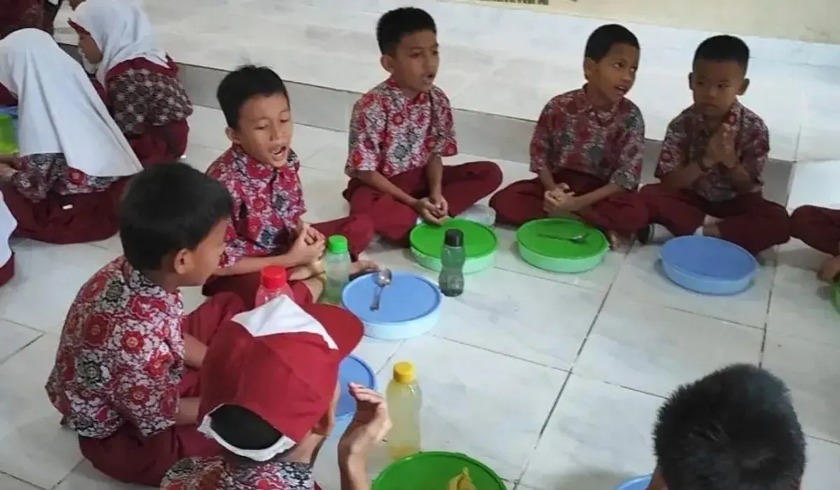 Petugas membagikan menu Makanan Bergizi Gratis (MBG) kepada siswa SDN 178 Palembang. Program kembali berjalan normal setelah insiden keracunan akhir September lalu. (Sumber: Istimewa)